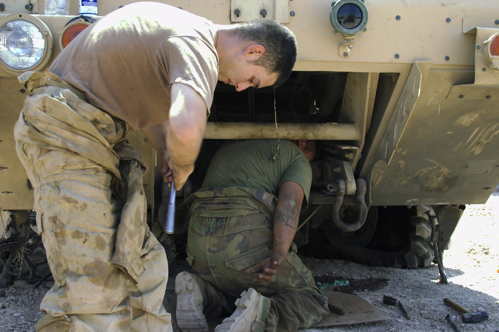 military men working on a piece of equipment